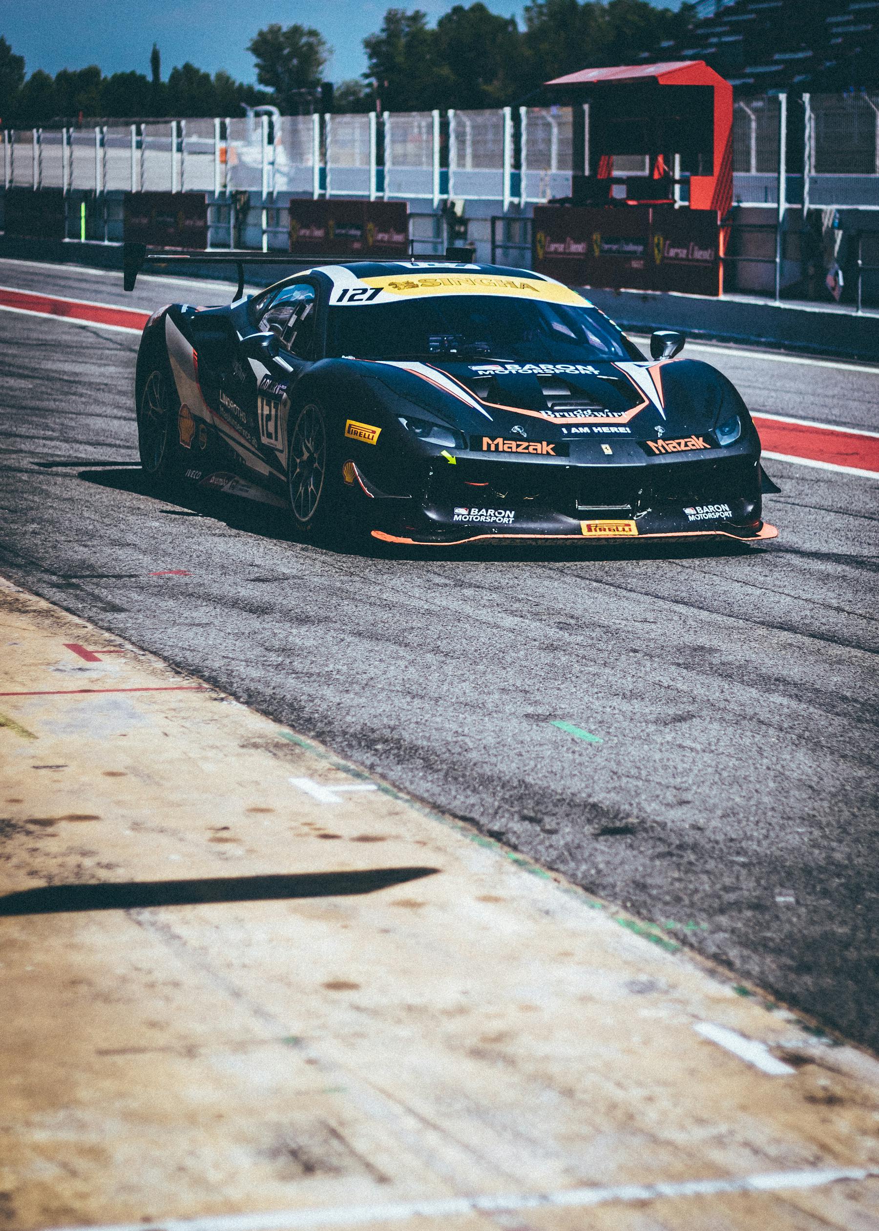 Black GT race car accelerating on a track
